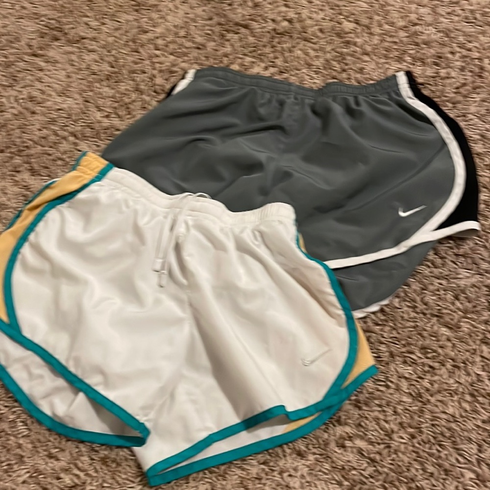 Two pair of Nike shorts gray one is large white one is medium.